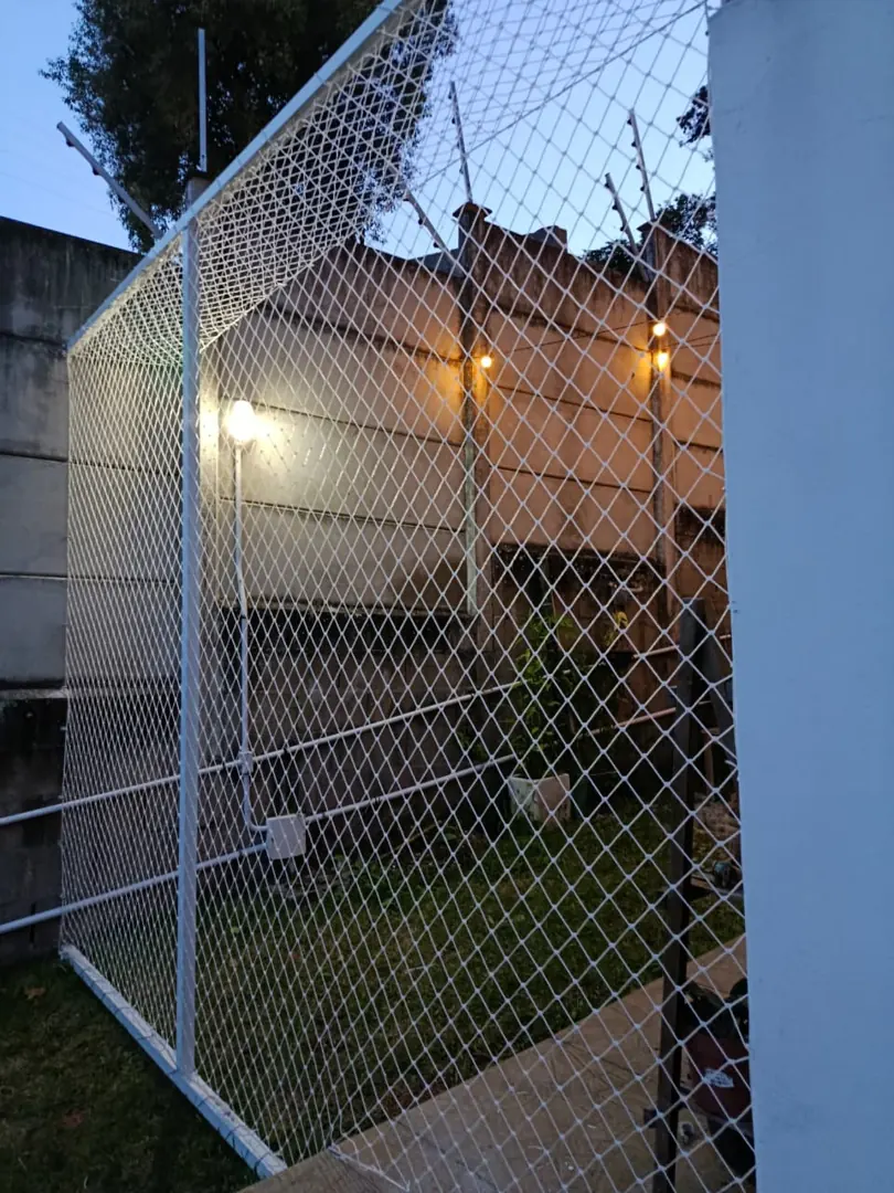 Rede branca fixada em estrutura na área externa de uma residência