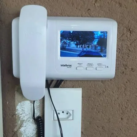 Vídeo porteiro com monitor e telefone instalado em parede residencial
